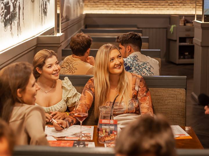 Two friends smiling at their table during the quiz